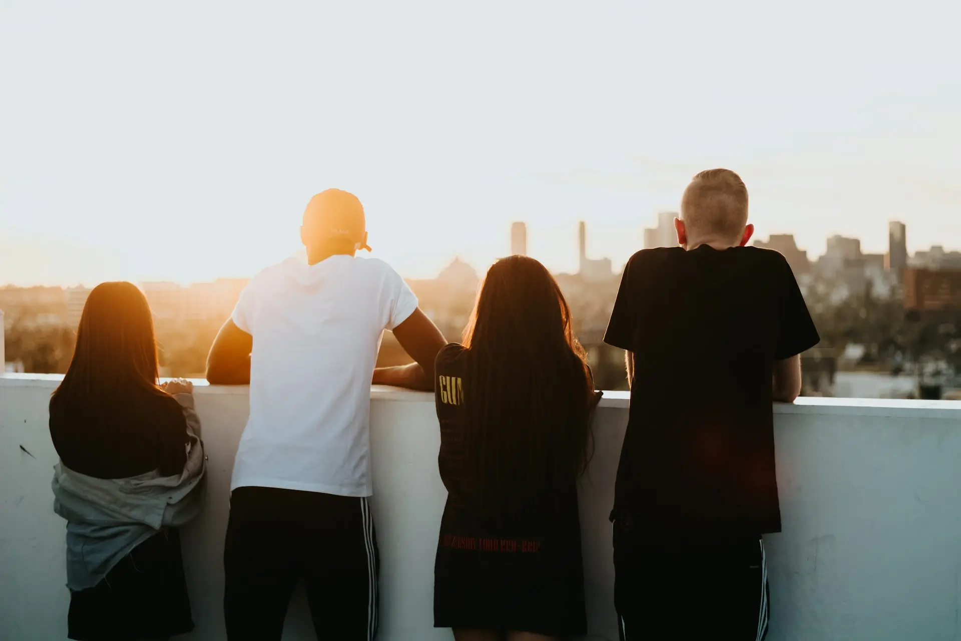 devin-avery-lhAy4wmkjSk-unsplash Group of people sitting together outdoors at sunset.